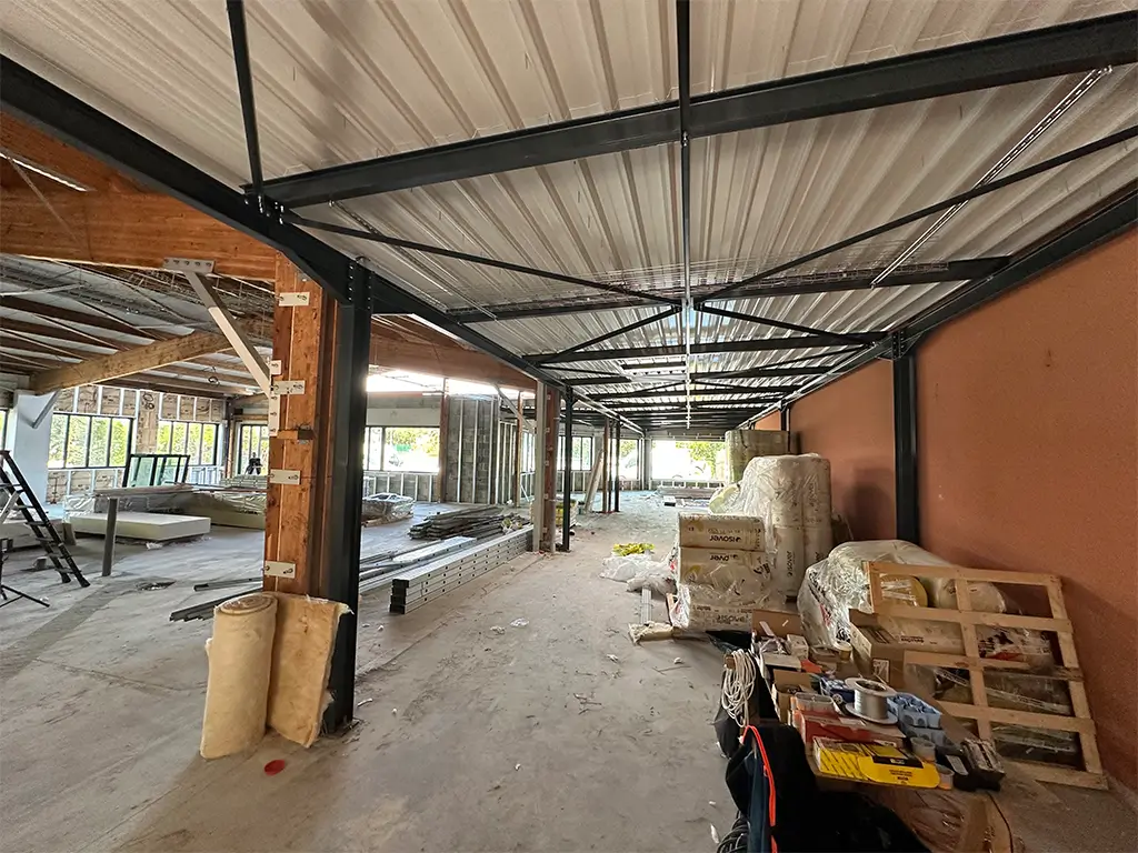Une photo de l'intérieur des Halles d'Isigny en chantier avec les charpentes bois et métalliques